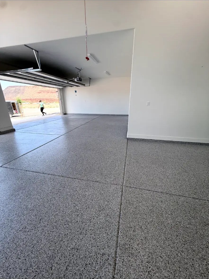 Sunlit flake floor with open garage door and desert view
